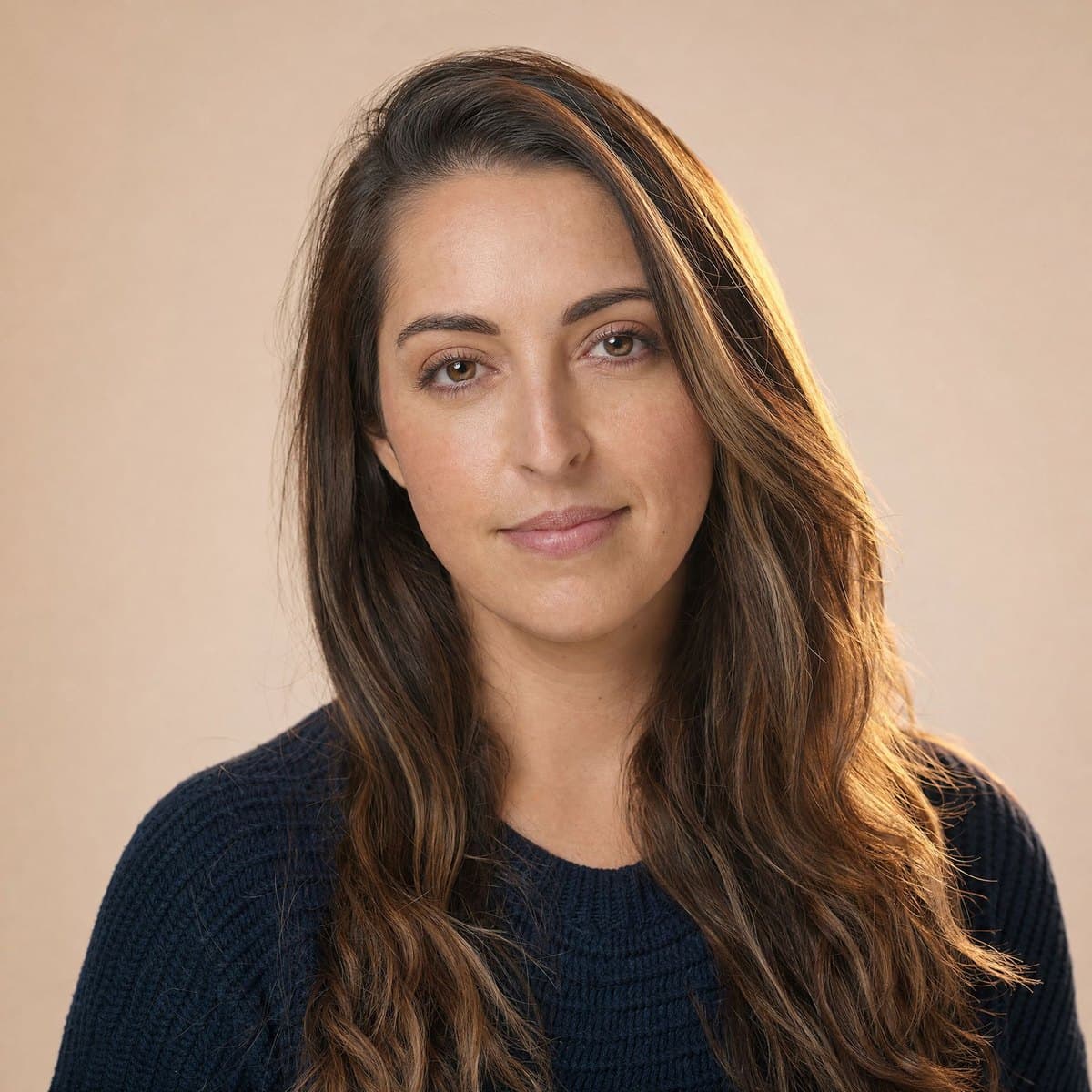 A calm woman in her early thirties in a navy knit