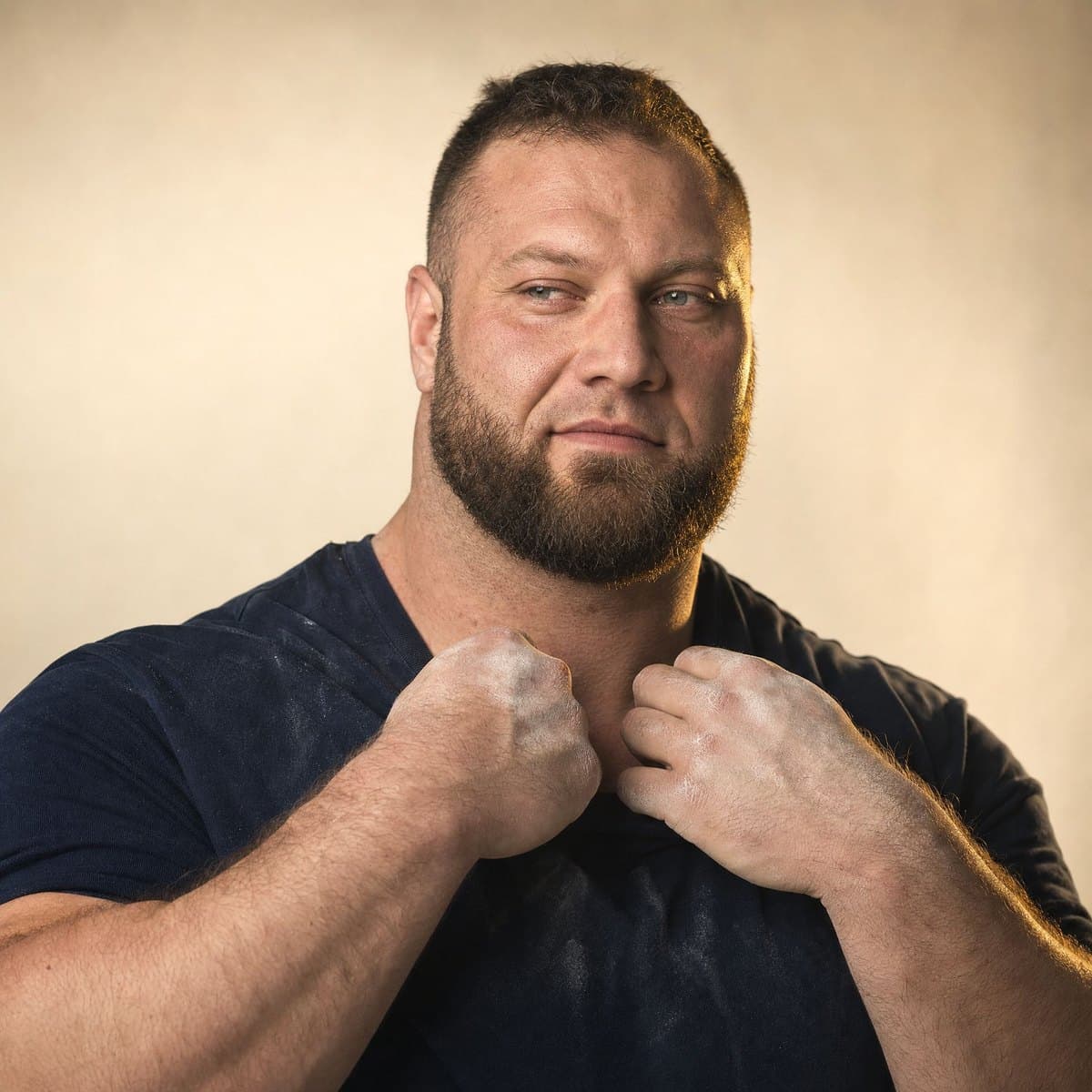 A strongman athlete with chalked hands, calm and confident
